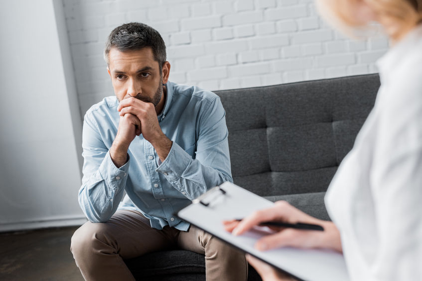 depressed adult man on psychologist therapy session at office